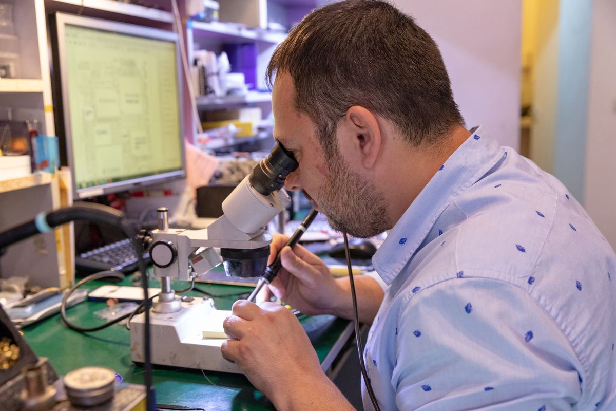 Fondatorul iFIX ALL lucrând la microscop, în service-ul din București