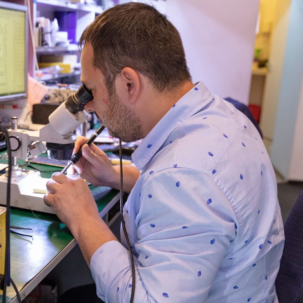 Lipire pe placă la microscop, cu stația de lipit alături, în service-ul iFIX ALL